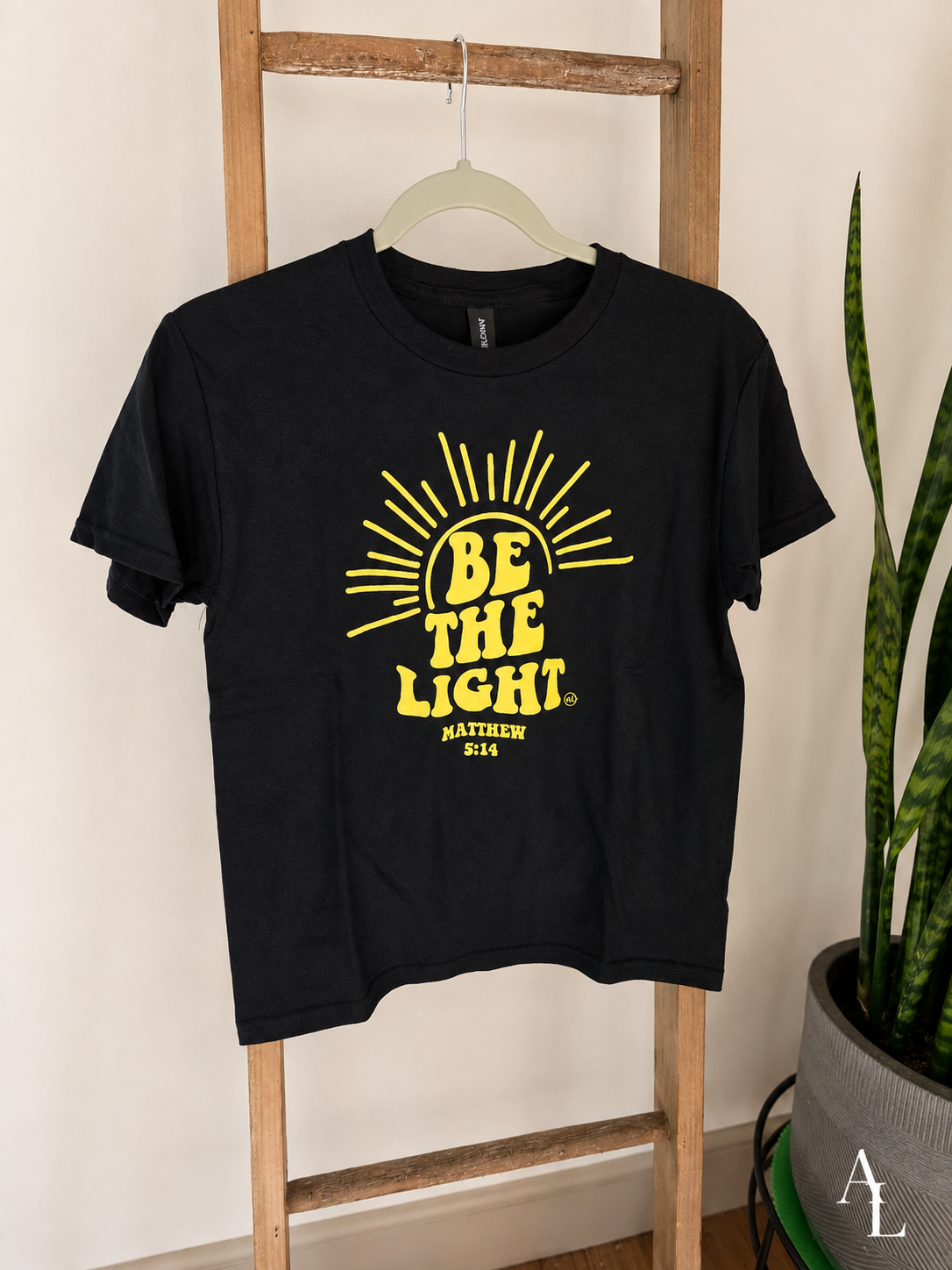 Black kids graphic tee featuring the "Be the Light" design inspired by Matthew 5:14, displayed on a hanger.