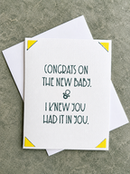 A white greeting card with dark green text reading 'CONGRATS ON THE NEW BABY. & I KNEW YOU HAD IT IN YOU.