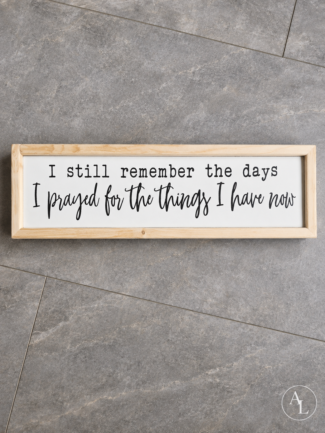 Framed wood sign featuring the quote "I Still Remember the Days I Prayed for the Things I Have Now" shown in a flat lay view.