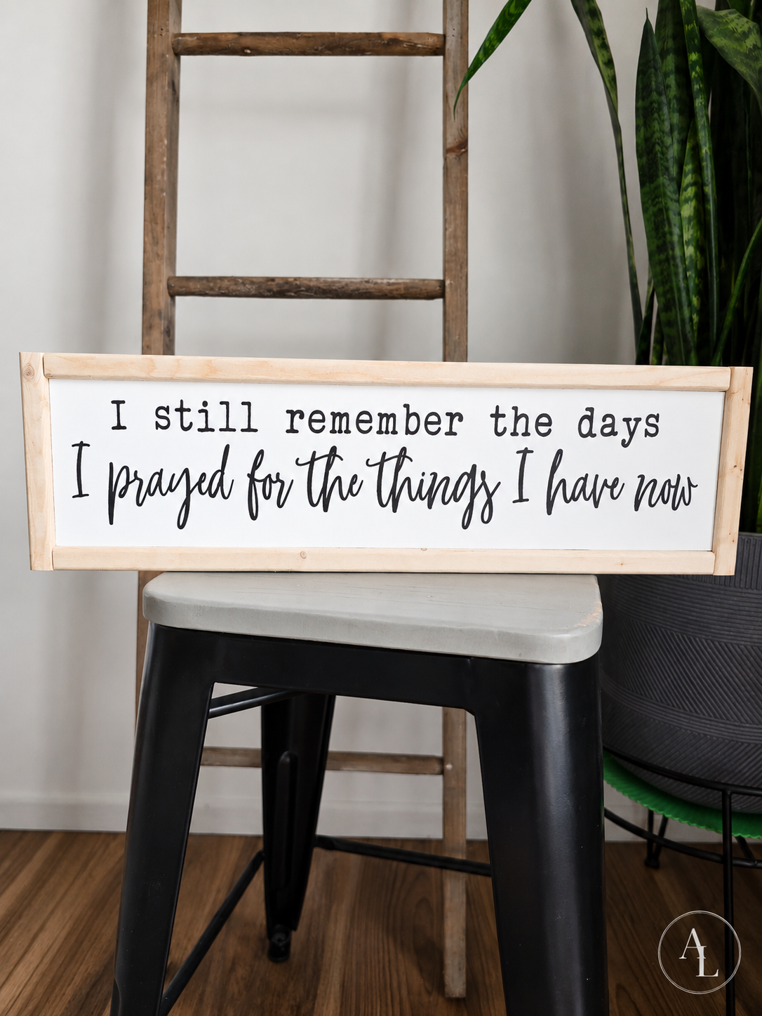 Framed wood sign displaying the quote "I Still Remember the Days I Prayed for the Things I Have Now" standing on display.